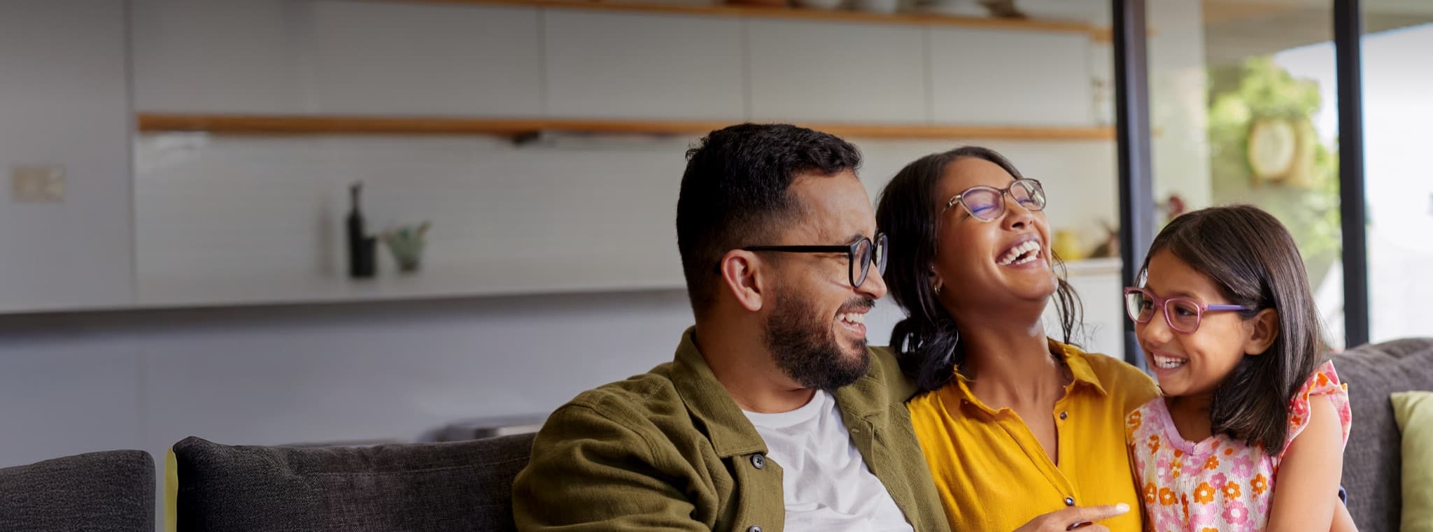 Family laughing together on couch